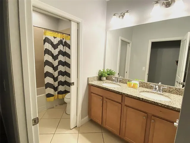 a spacious bathroom with a granite countertop sink and a mirror