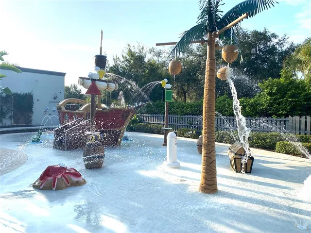 a swimming pool with some plants and large trees