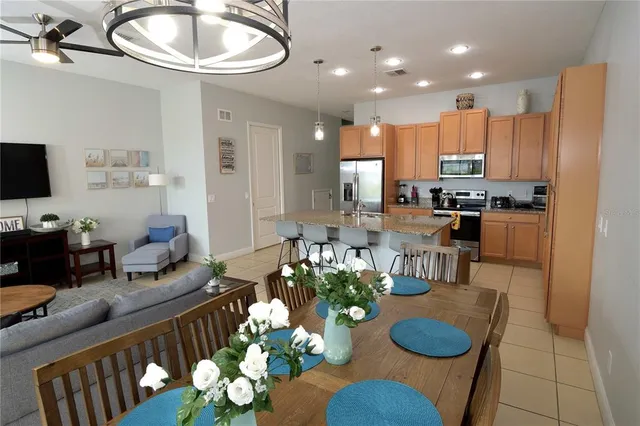 a living room with furniture kitchen view and a chandelier