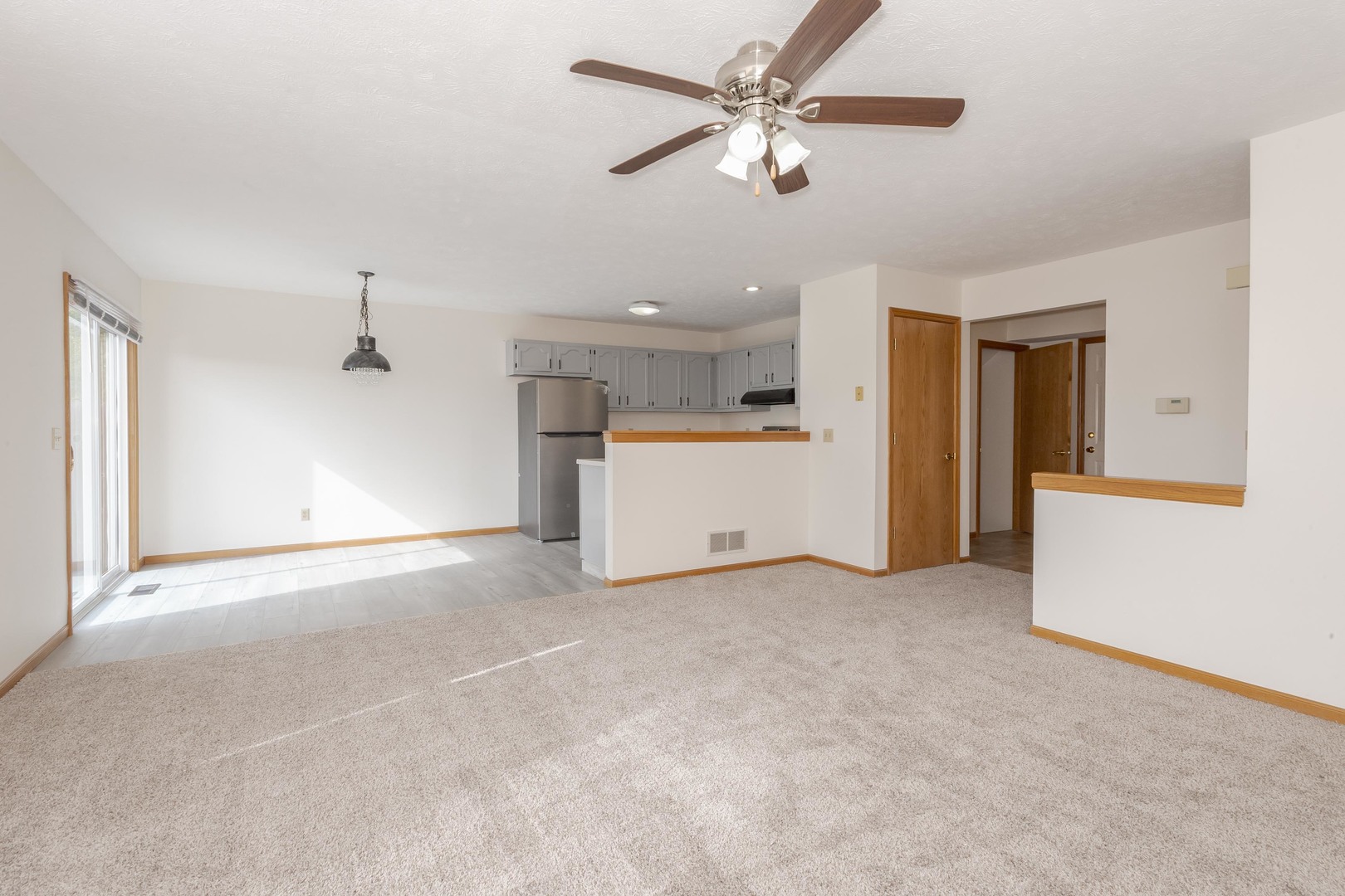 26 Vermont Avenue Bloomington, IL 61701 - Photo 6 of 37 an empty room with a ceiling fan and a kitchen view