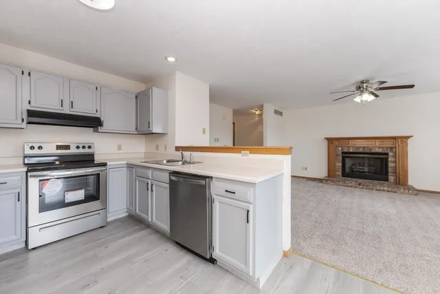 a kitchen with granite countertop a stove top oven and cabinets