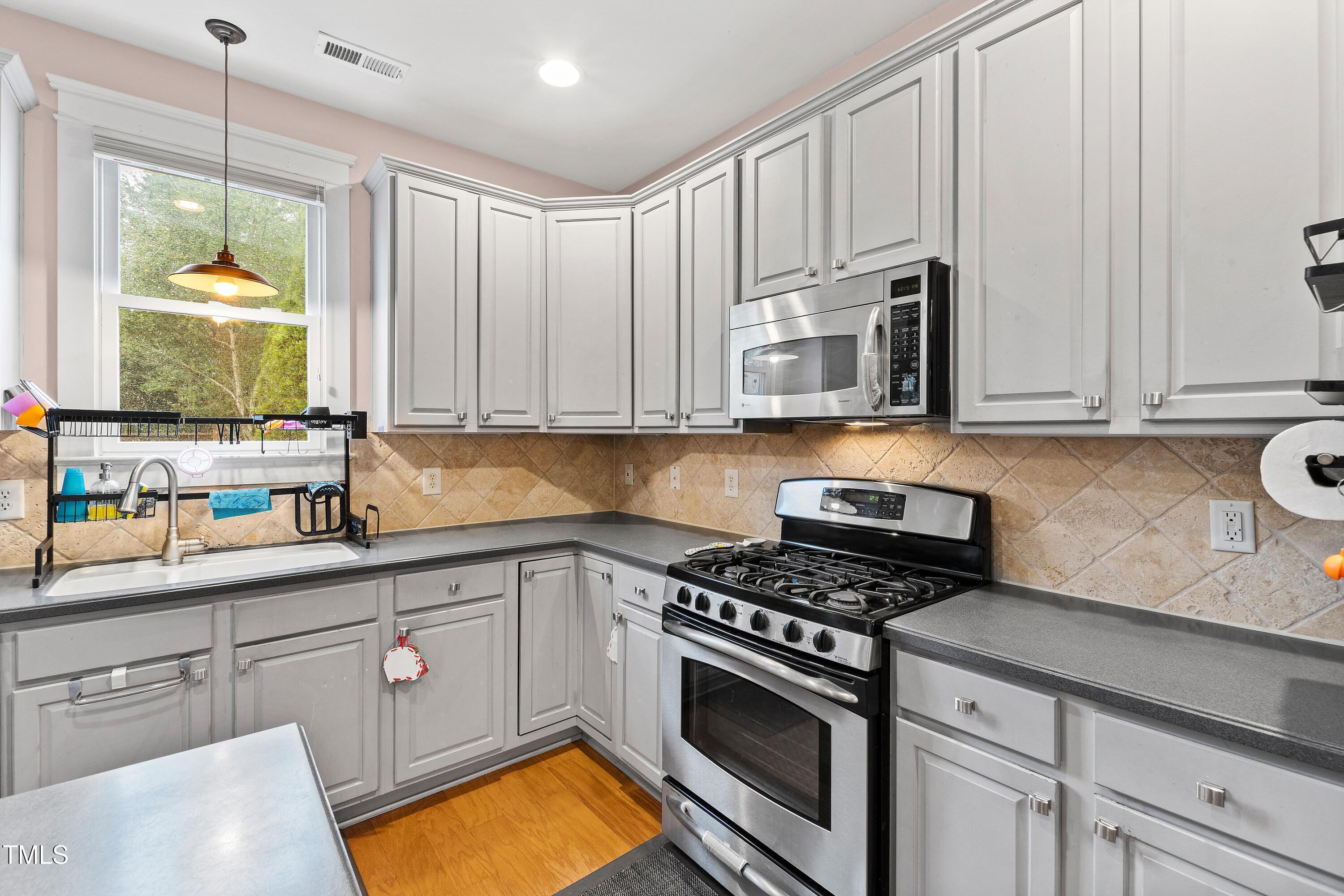 204 Frontgate Drive Cary, NC 27519 - Photo 14 of 41 a kitchen with stainless steel appliances a stove a sink and a microwave