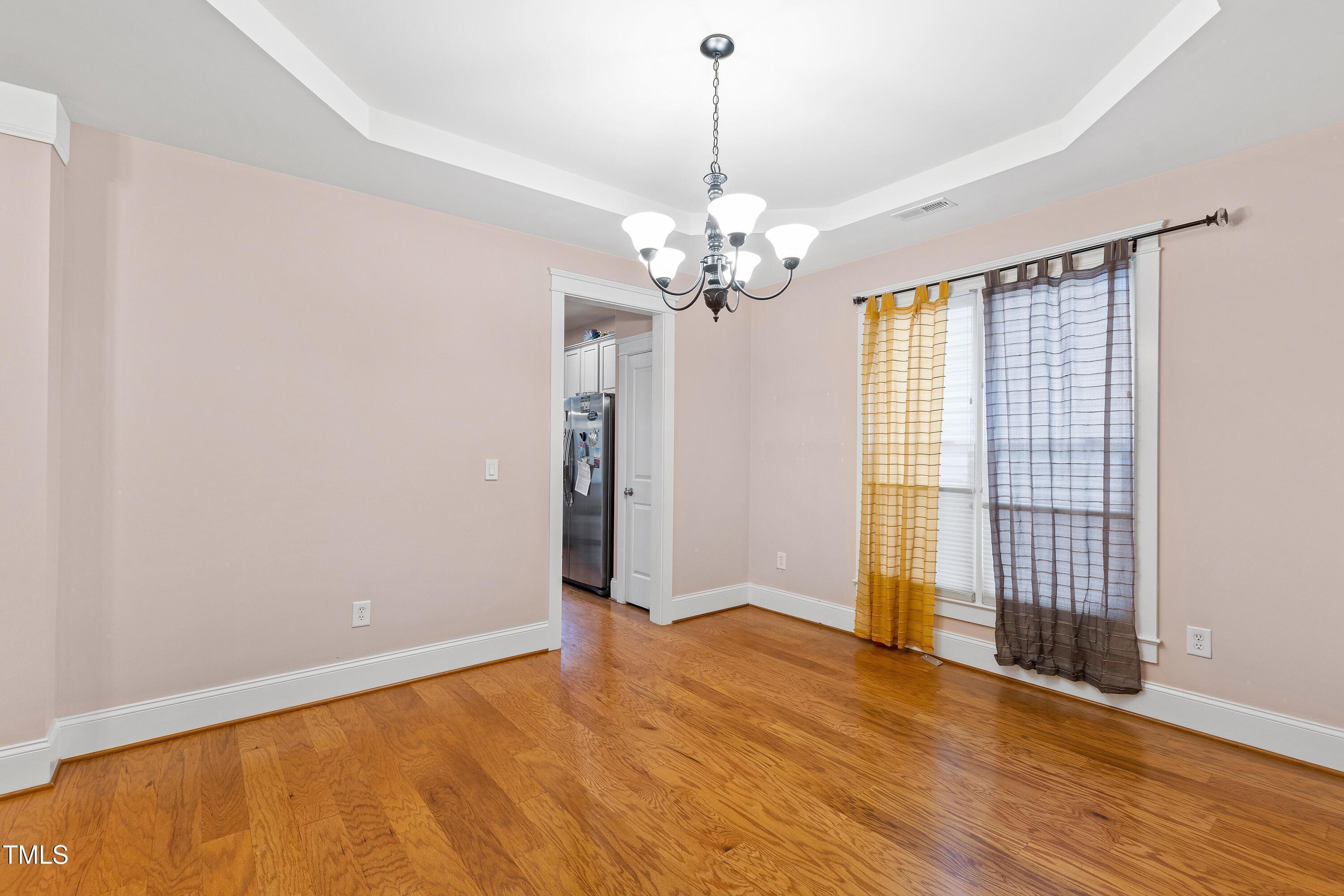 204 Frontgate Drive Cary, NC 27519 - Photo 9 of 41 a view of an empty room with wooden floor and a window