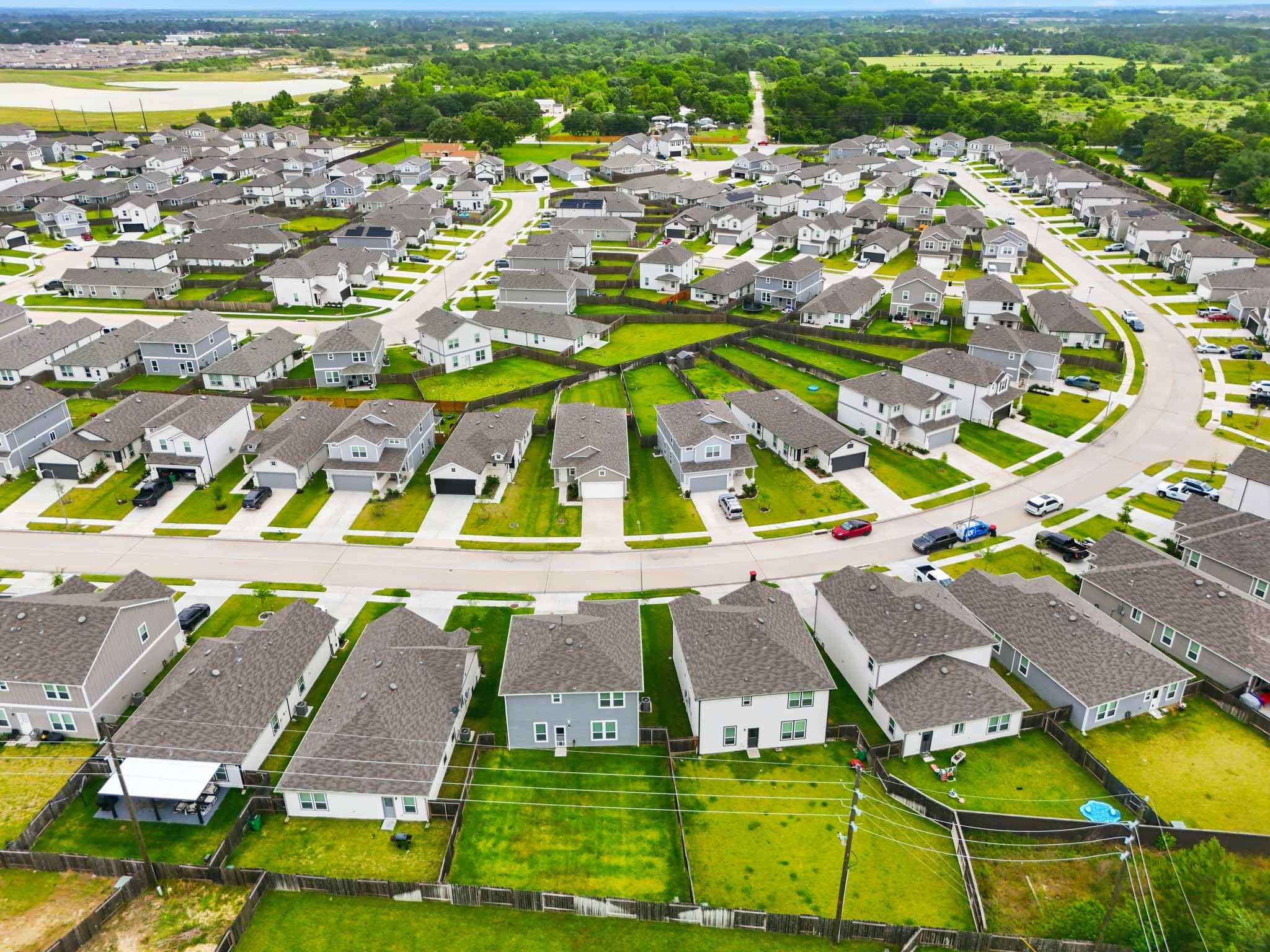 23427 Weir Box Road Hockley, TX 77447 - Photo 32 of 32 An expansive aerial view showcasing the masterfully designed layout of the Windrow development. This perspective highlights the tidy curb appeal, curved streets, and excellent spacing between homes.