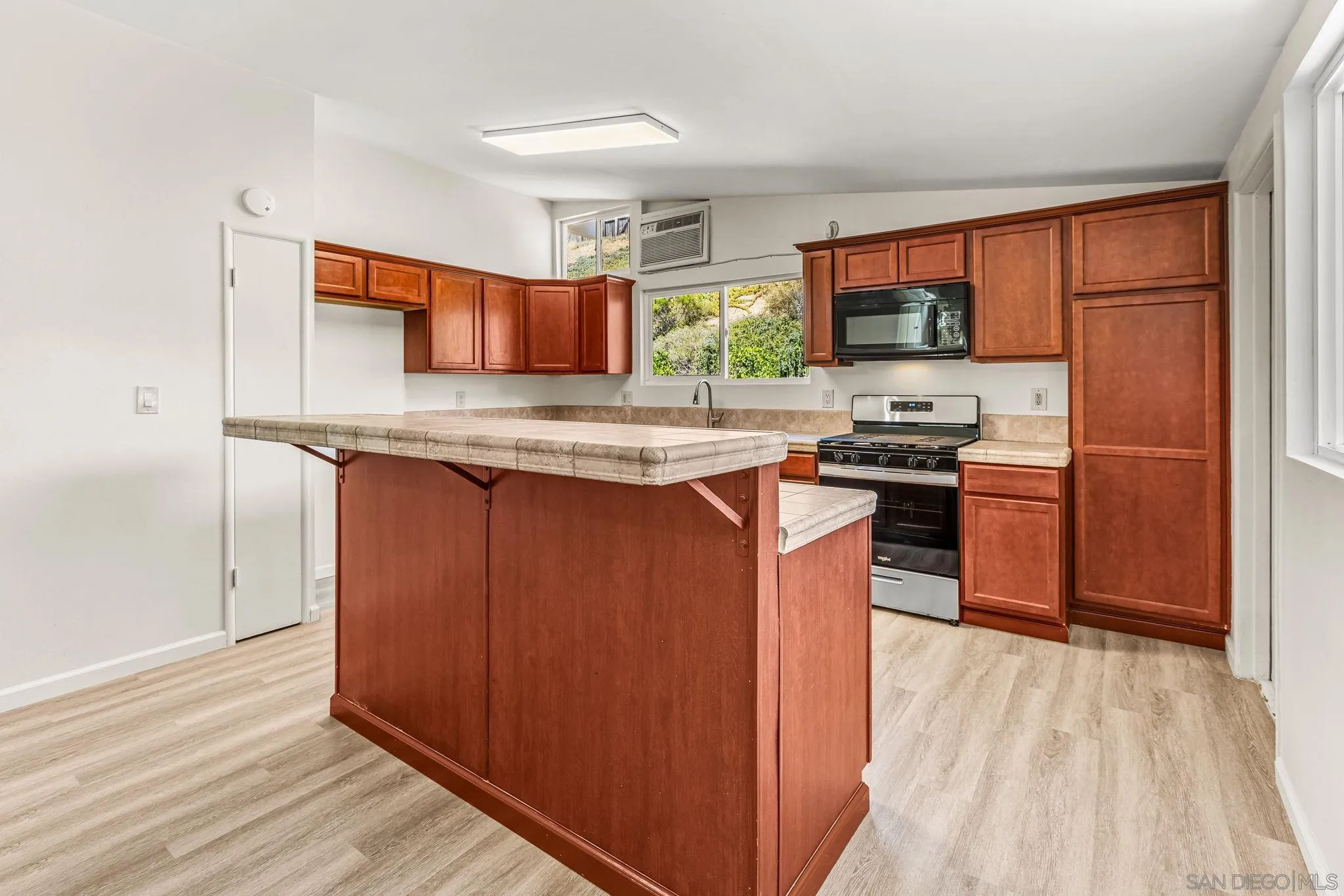 13323 Frame Road Poway, CA 92064 - Photo 6 of 30 a kitchen with stainless steel appliances granite countertop a stove a sink dishwasher and a refrigerator with wooden floor
