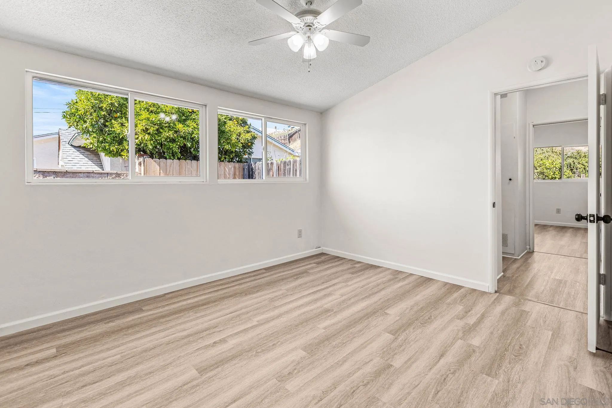 13323 Frame Road Poway, CA 92064 - Photo 10 of 30 an empty room with wooden floor fan and windows