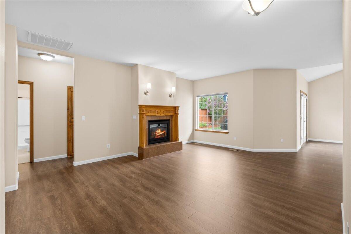 802 Ridgeway Avenue Central Point, OR 97502 - Photo 9 of 33 an empty room with wooden floor fireplace and windows
