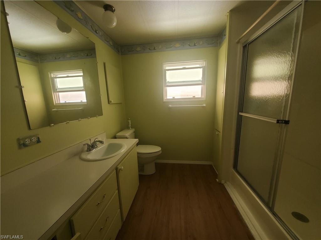 40 Enchanting Boulevard, Unit E40 Naples, FL 34112 - Photo 4 of 9 a bathroom with a sink and mirror with toilet