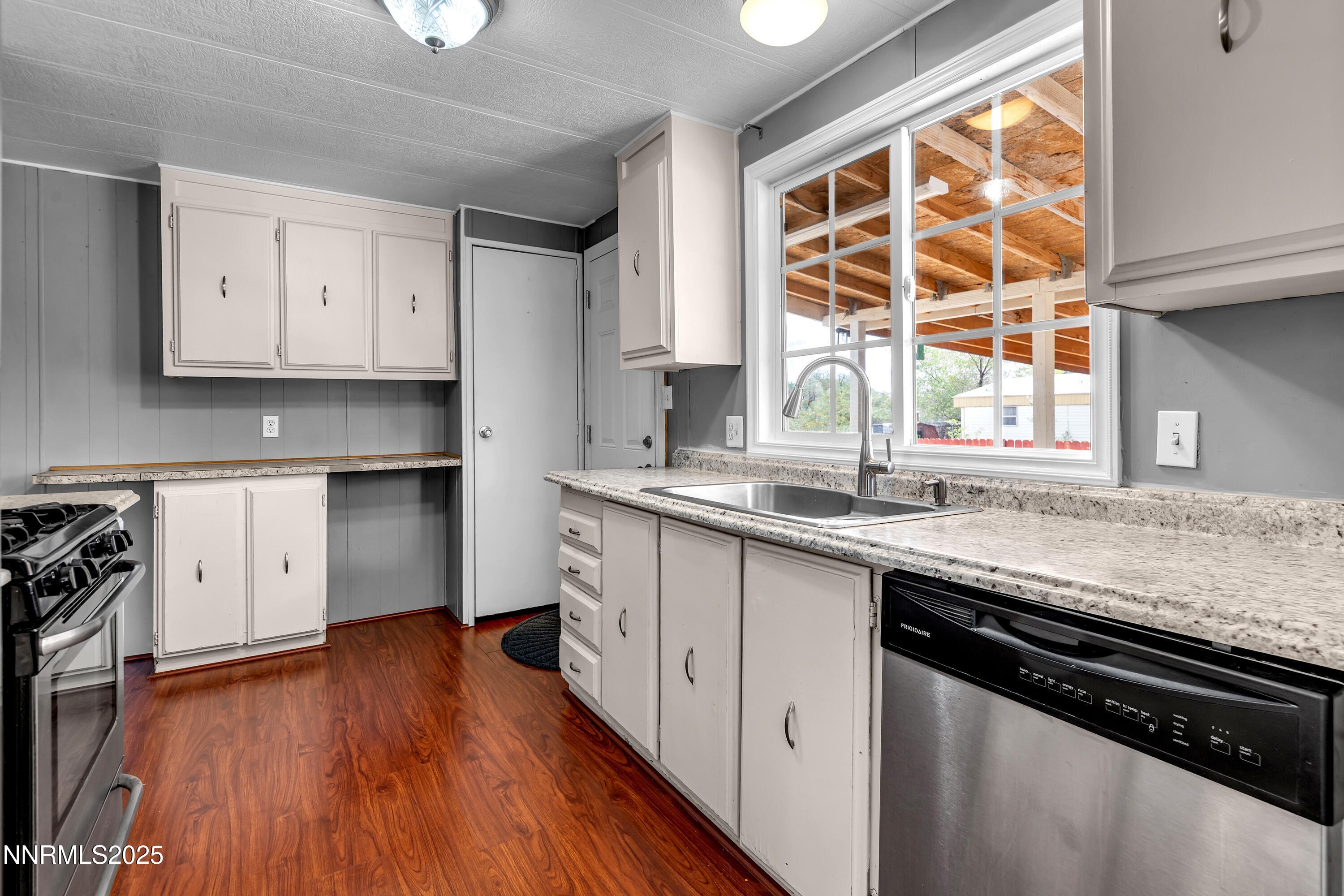 5760 Leon Drive Sun Valley, NV 89433 - Photo 11 of 42 a kitchen with stainless steel appliances granite countertop a sink a stove and a window