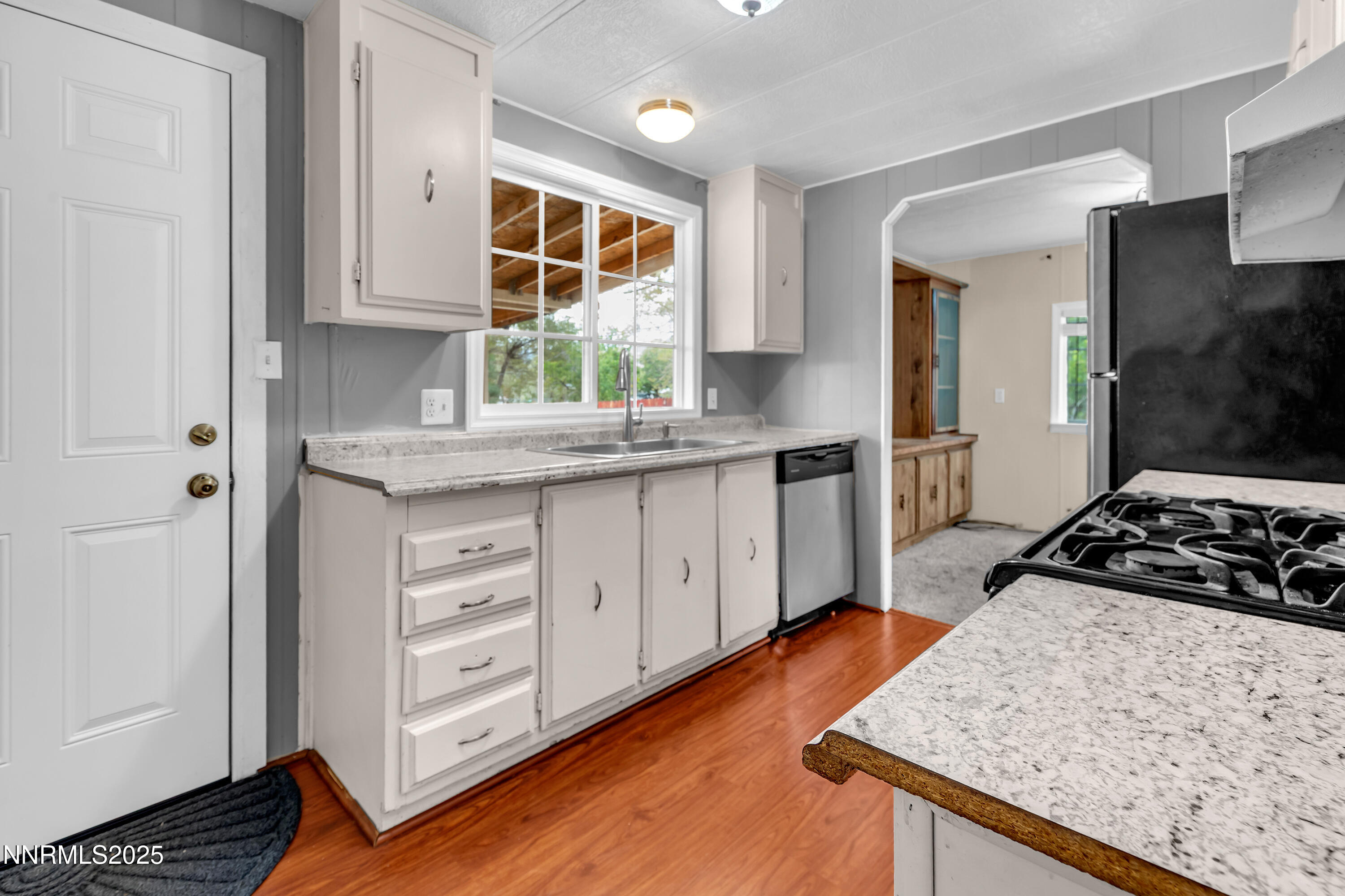 5760 Leon Drive Sun Valley, NV 89433 - Photo 13 of 42 a kitchen with granite countertop a stove a sink and a refrigerator