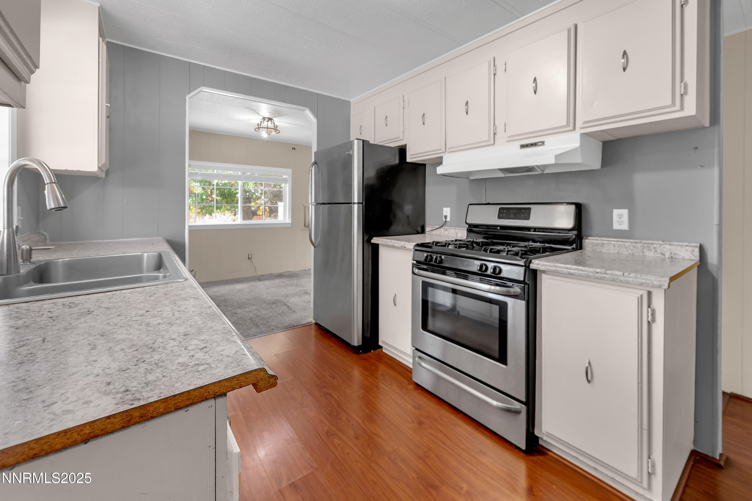 5760 Leon Drive Sun Valley, NV 89433 - Photo 14 of 42 a kitchen with granite countertop a sink stainless steel appliances and cabinets