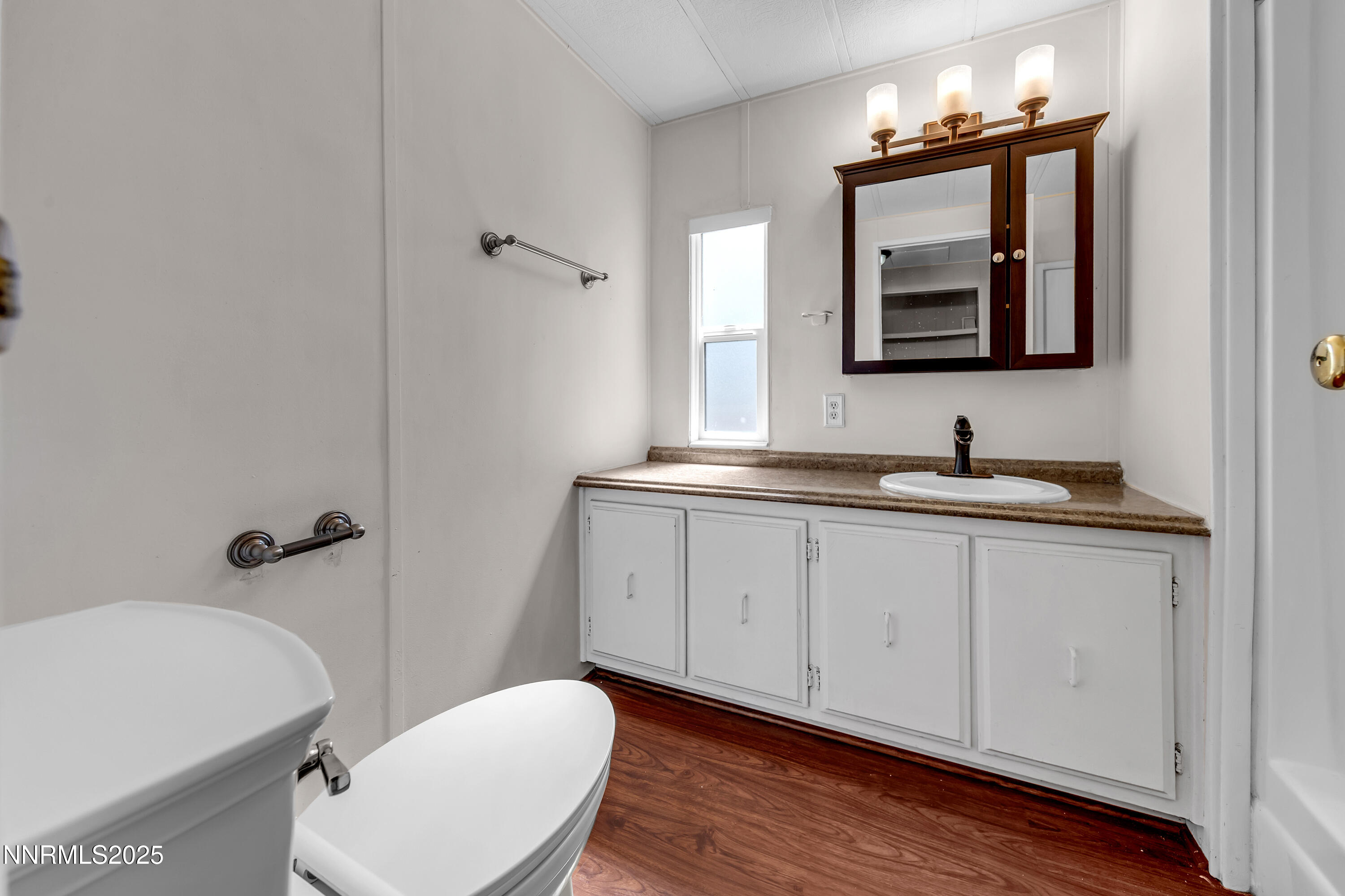 5760 Leon Drive Sun Valley, NV 89433 - Photo 27 of 42 a bathroom with a toilet a sink and mirror