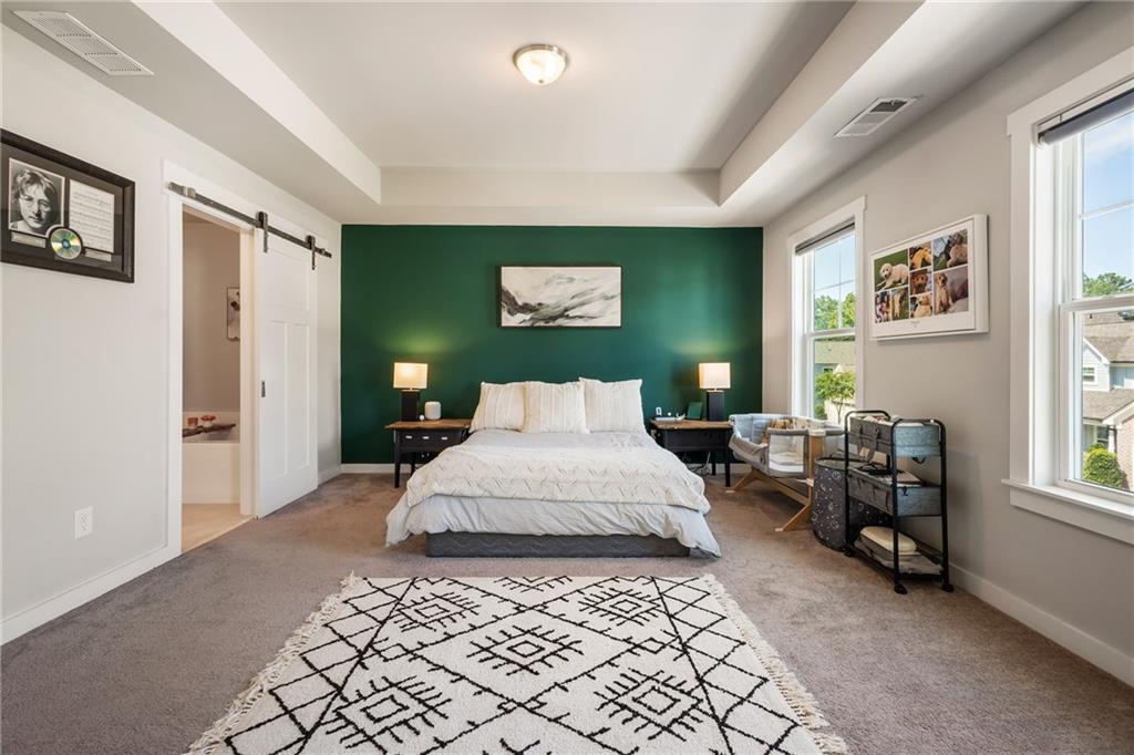 278 Perry Point Run, Unit 56 Lawrenceville, GA 30046 - Photo 17 of 36 a spacious bedroom with a bed and a computer on the table