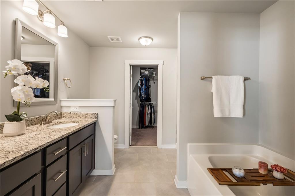 278 Perry Point Run, Unit 56 Lawrenceville, GA 30046 - Photo 18 of 36 a bathroom with a granite countertop sink and a mirror