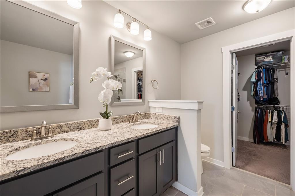 278 Perry Point Run, Unit 56 Lawrenceville, GA 30046 - Photo 19 of 36 a bathroom with a granite countertop sink a toilet and a mirror
