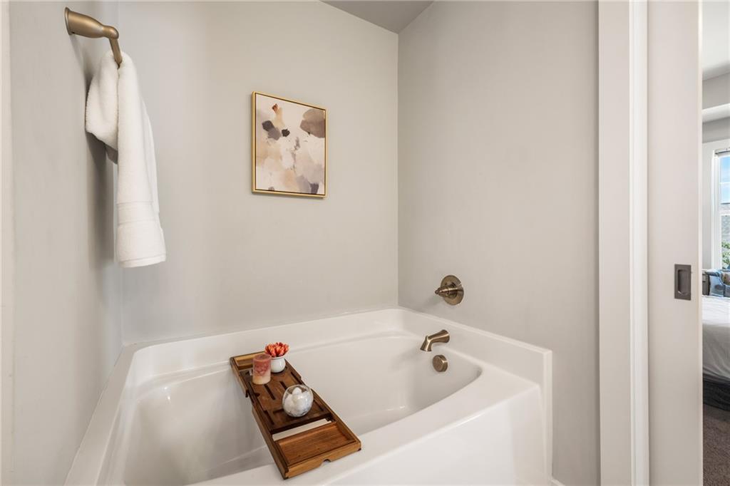 278 Perry Point Run, Unit 56 Lawrenceville, GA 30046 - Photo 20 of 36 a bath tub sitting next to a white sink and vanity