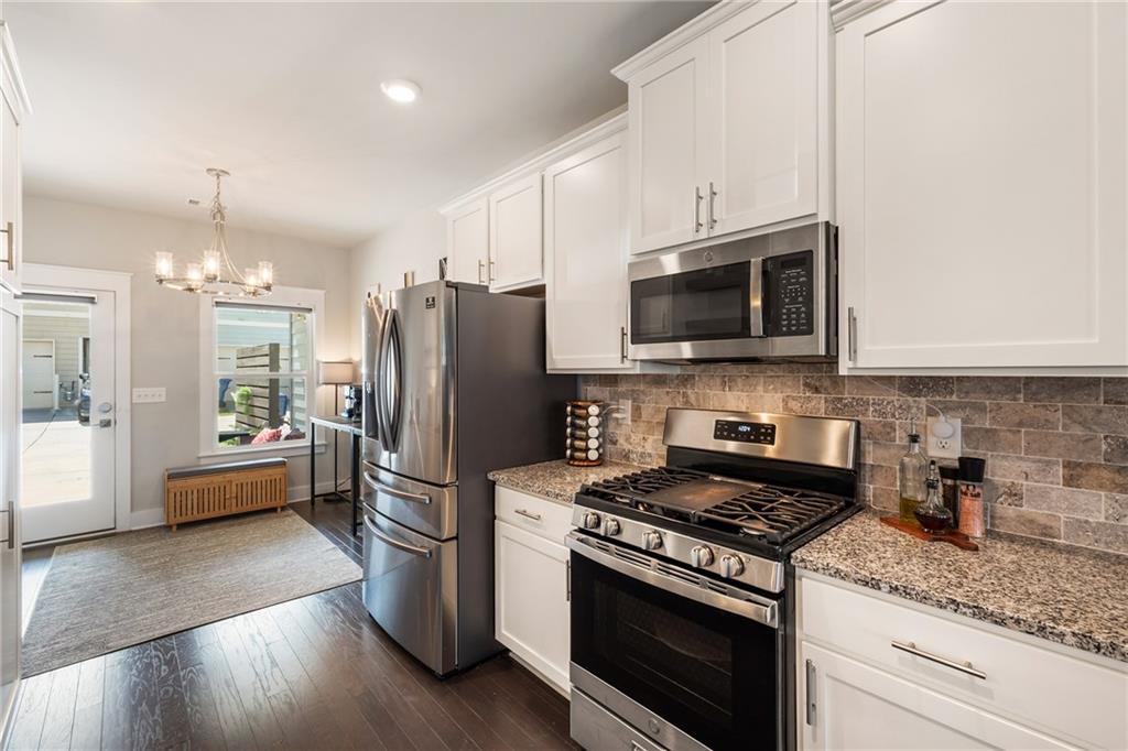 278 Perry Point Run, Unit 56 Lawrenceville, GA 30046 - Photo 4 of 36 a kitchen with stainless steel appliances granite countertop a stove refrigerator and microwave