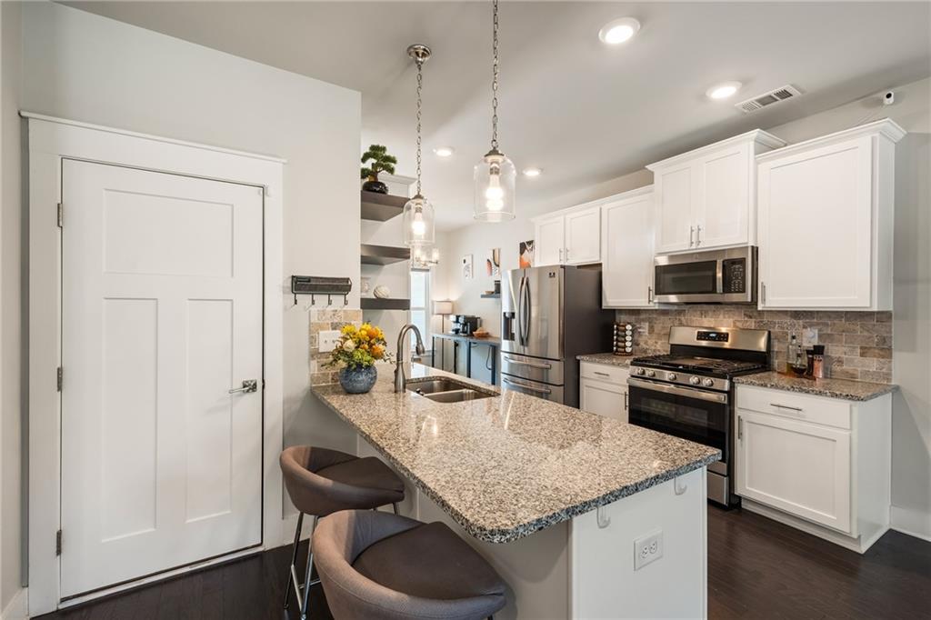 278 Perry Point Run, Unit 56 Lawrenceville, GA 30046 - Photo 10 of 36 a kitchen with stainless steel appliances granite countertop a sink refrigerator and microwave