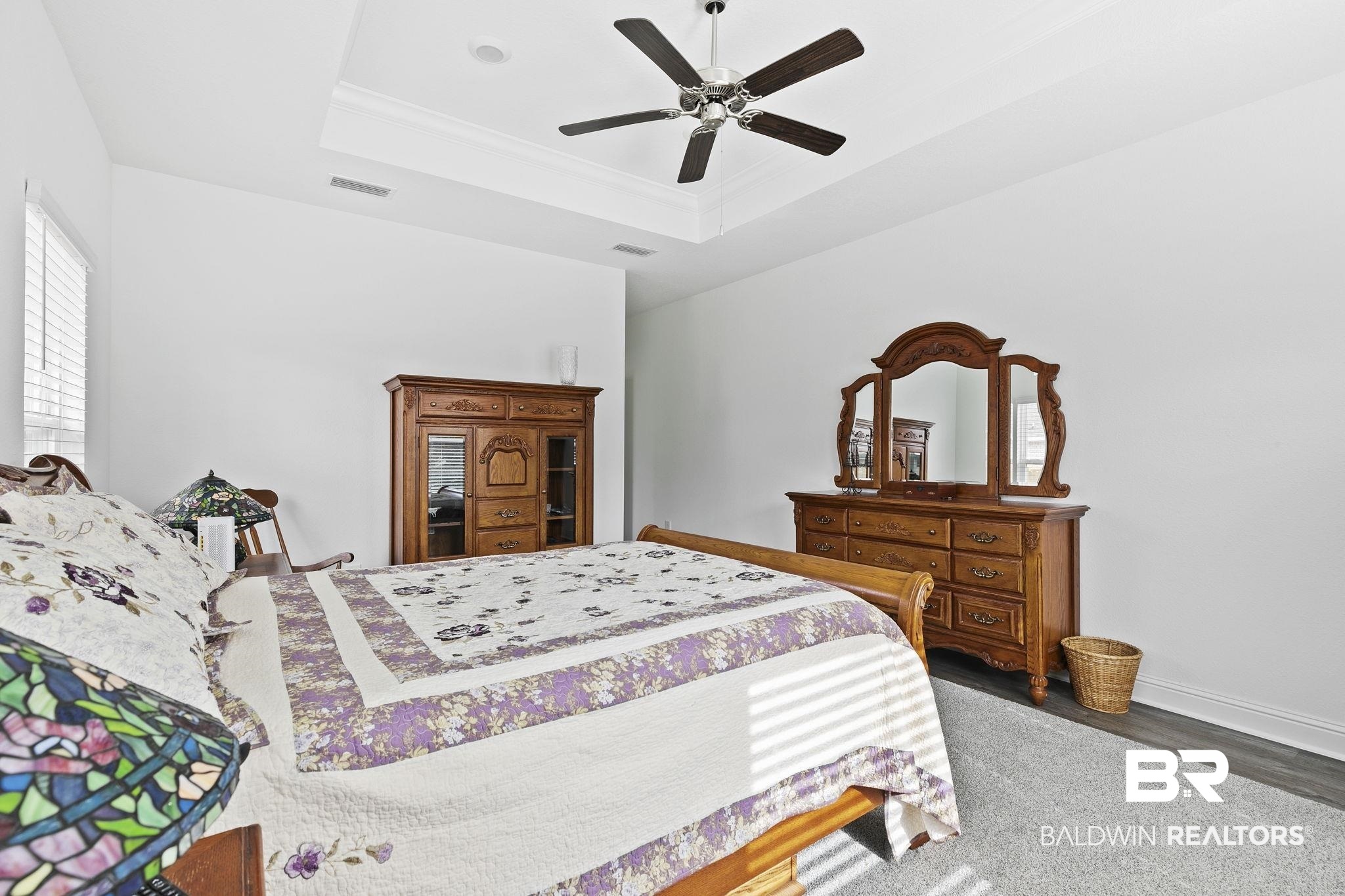 1141 Pencarro Boulevard Foley, AL 36535 - Photo 30 of 70 Bedroom with dark wood-type flooring, ceiling fan, a tray ceiling, and crown molding
