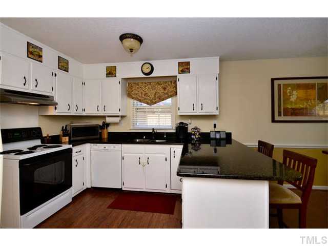7309 Mine Valley Road Raleigh, NC 27615 - Photo 5 of 15 a kitchen with stainless steel appliances granite countertop a stove a sink and a refrigerator