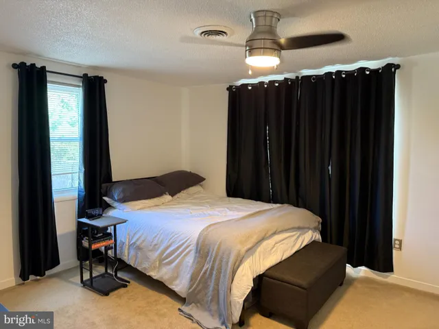 a bedroom with a bed a dresser and a mirror