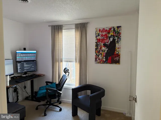 a view of a workspace with furniture and a window