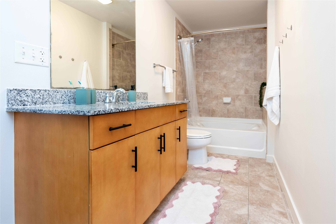 360 Nueces Street, Unit 1214 Austin, TX 78701 - Photo 17 of 38 a bathroom with a granite countertop sink a toilet and shower