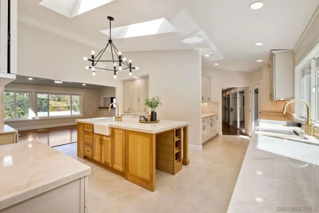 a kitchen that has a lot of white cabinets and stainless steel appliances