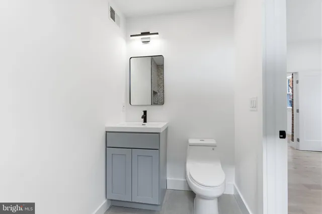 a bathroom with a toilet sink and mirror