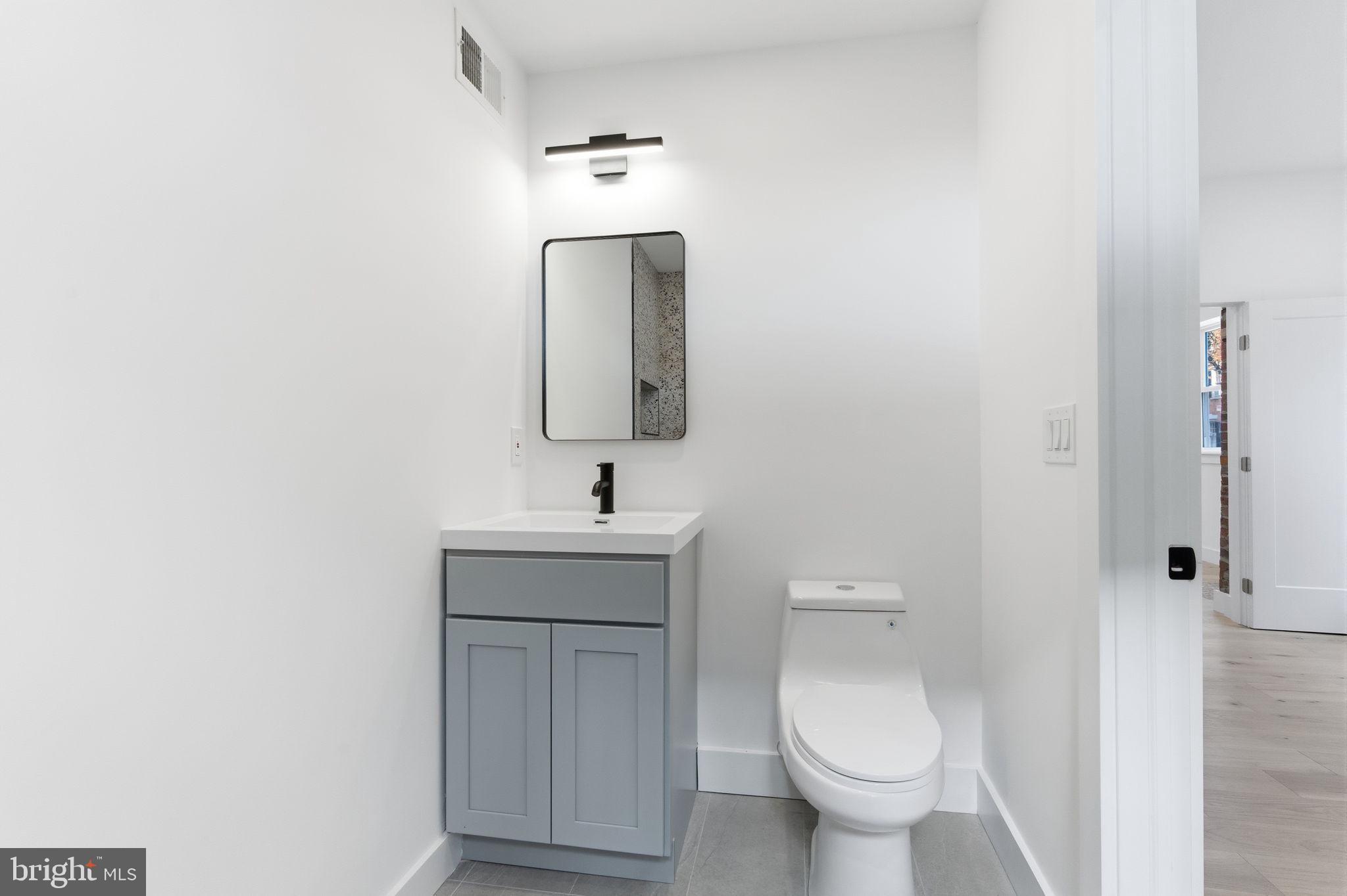 2724-26 East Somerset Street, Unit 1 Philadelphia, PA 19134 - Photo 12 of 21 a bathroom with a toilet sink and mirror