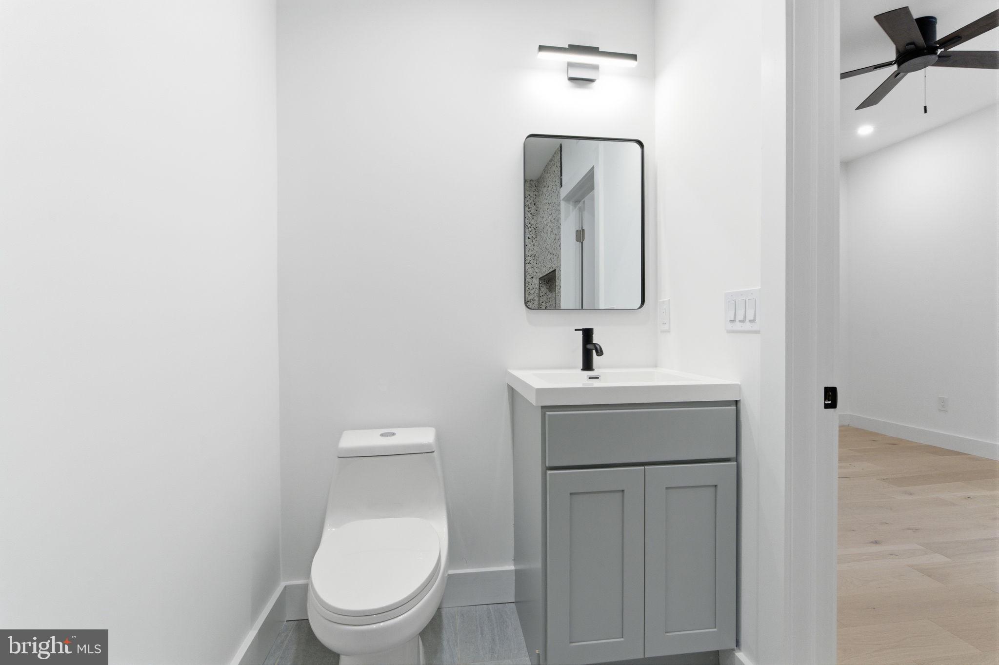 2724-26 East Somerset Street, Unit 1 Philadelphia, PA 19134 - Photo 16 of 21 a bathroom with a toilet a sink and mirror