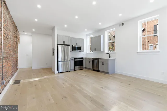 a view of kitchen with stainless steel appliances refrigerator oven and cabinets