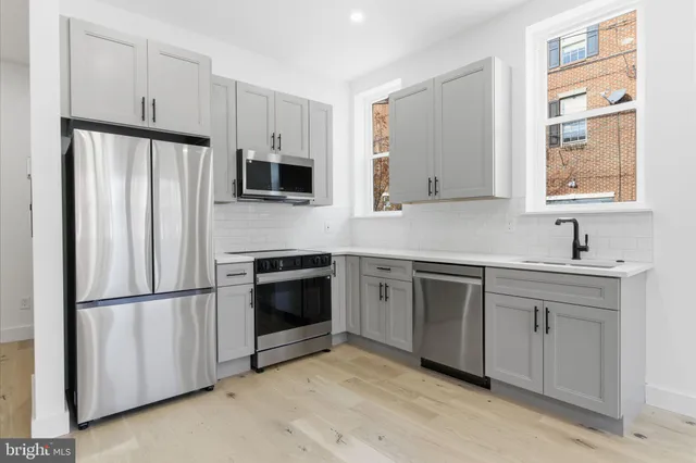 a kitchen with stainless steel appliances granite countertop a refrigerator sink and stove