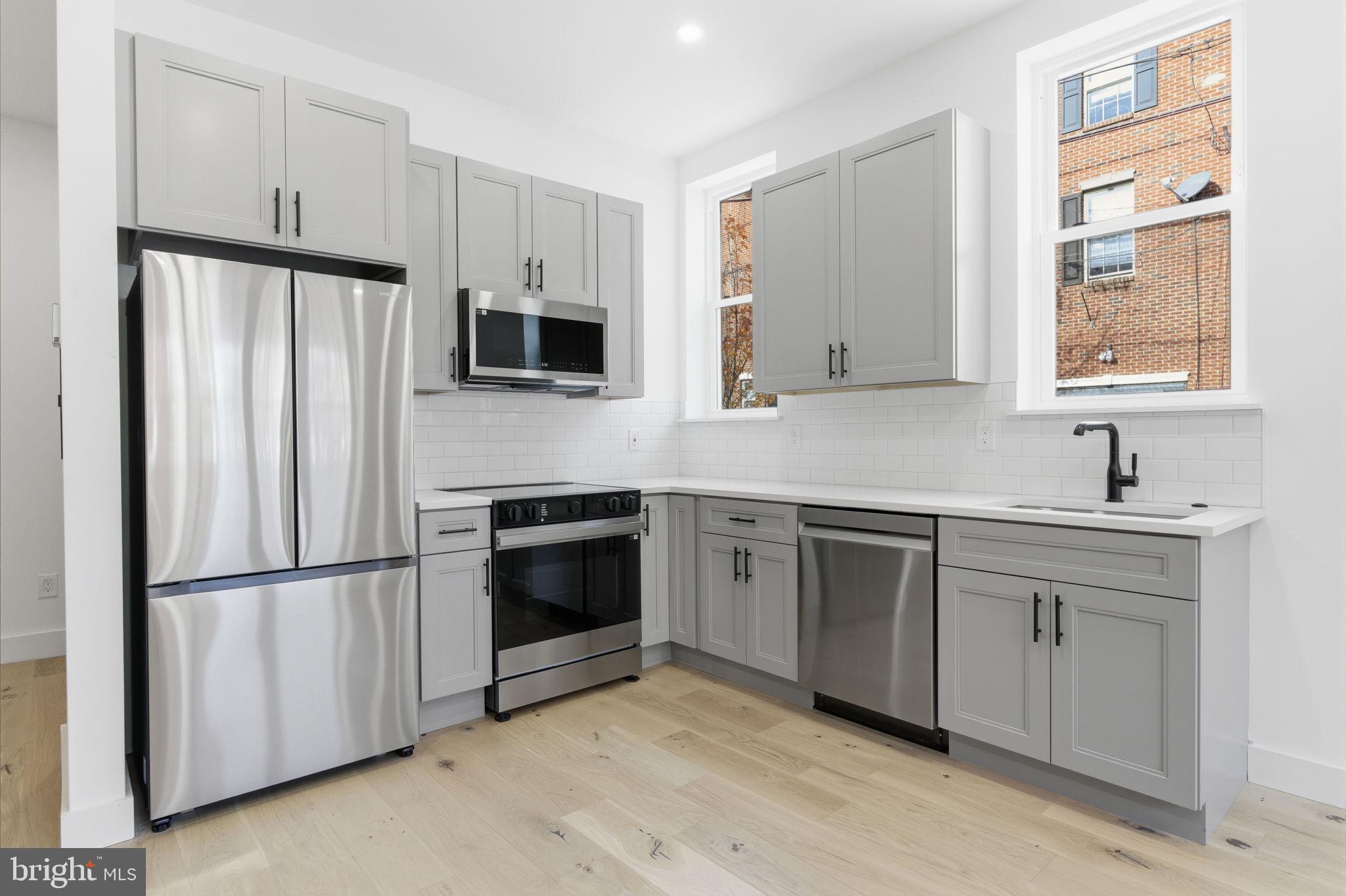 2724-26 East Somerset Street, Unit 1 Philadelphia, PA 19134 - Photo 5 of 21 a kitchen with stainless steel appliances granite countertop a refrigerator sink and stove