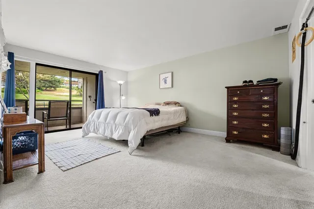 a spacious bedroom with a bed and large windows