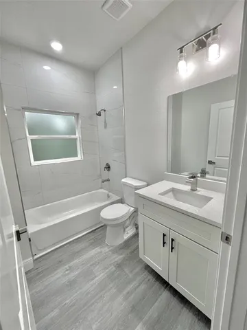 a bathroom with a tub sink toilet and a mirror
