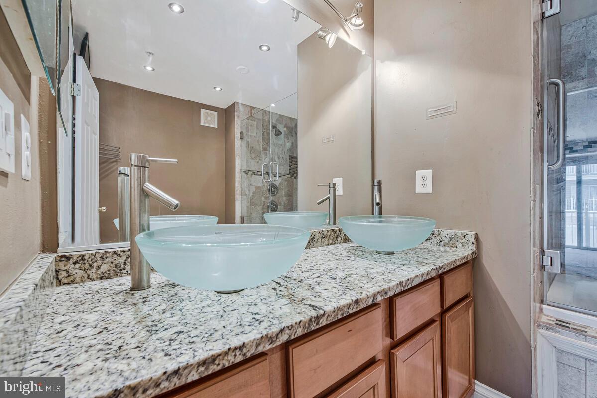 12354 Rollys Ridge Avenue, Unit 2201 Upper Marlboro, MD 20774 - Photo 17 of 20 a bathroom with a granite countertop sink and a mirror