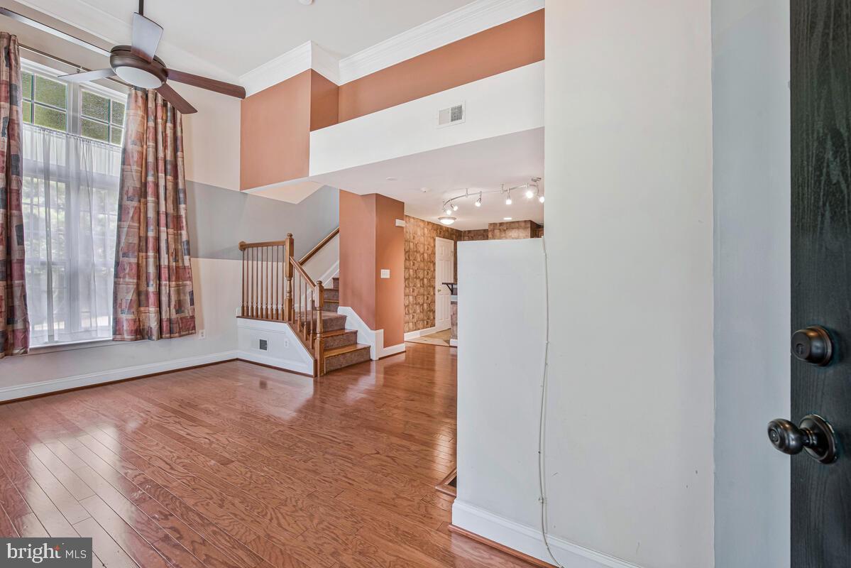 12354 Rollys Ridge Avenue, Unit 2201 Upper Marlboro, MD 20774 - Photo 3 of 20 a view of a livingroom with wooden floor and a staircase