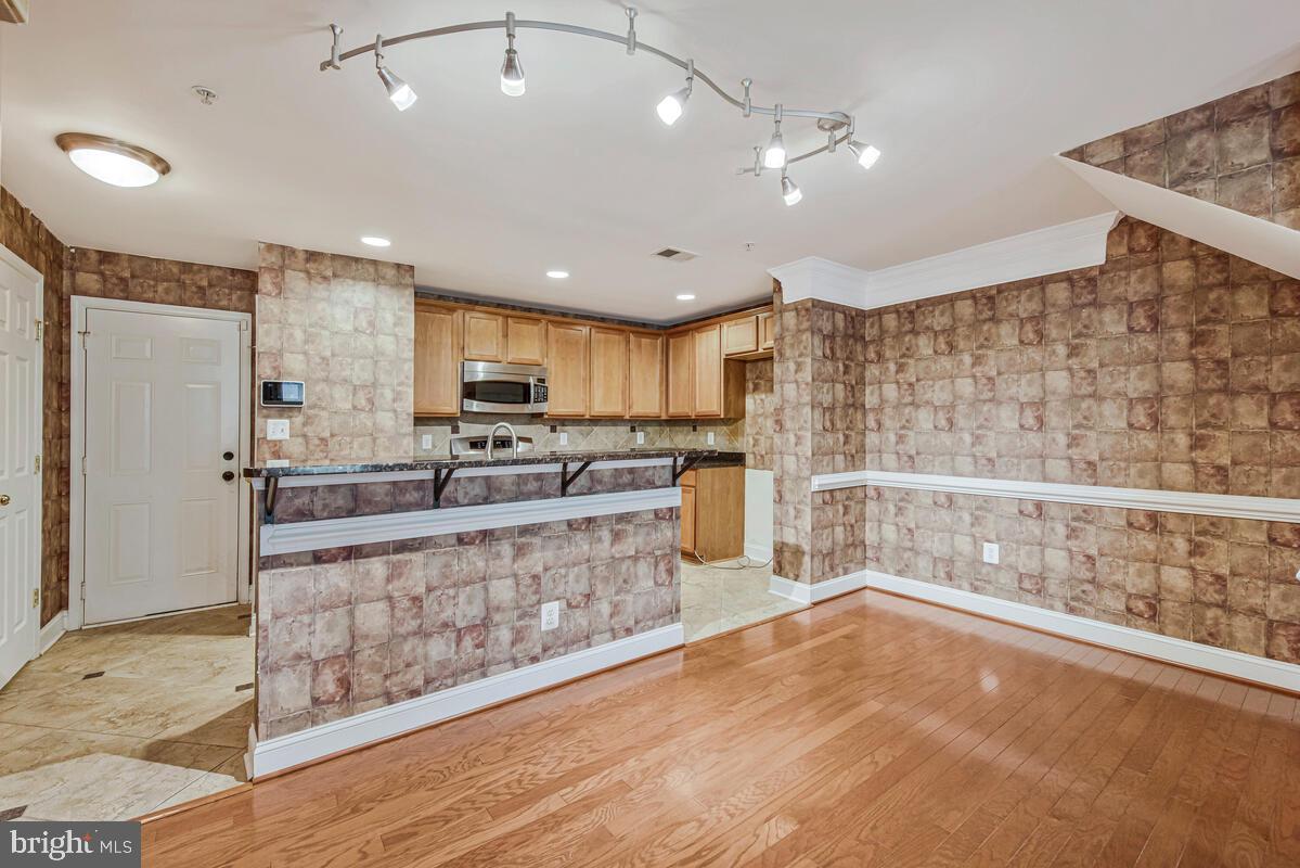 12354 Rollys Ridge Avenue, Unit 2201 Upper Marlboro, MD 20774 - Photo 7 of 20 a large kitchen with stainless steel appliances kitchen island granite countertop a refrigerator and a stove top oven