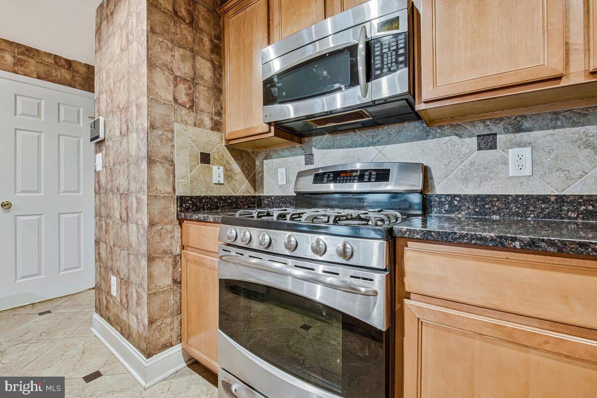 12354 Rollys Ridge Avenue, Unit 2201 Upper Marlboro, MD 20774 - Photo 10 of 20 a kitchen with stainless steel appliances granite countertop a stove microwave and cabinets