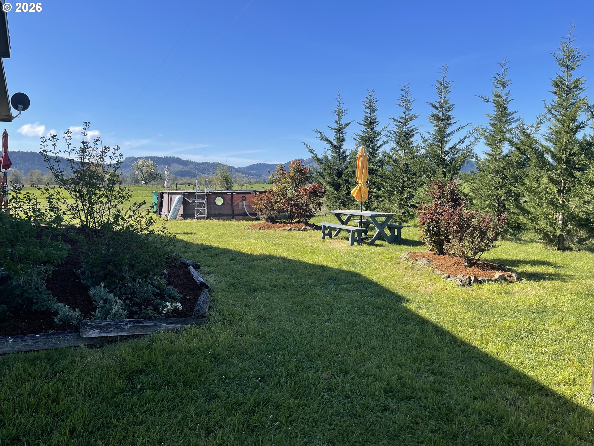 6404 Lookingglass Road Roseburg, OR 97471 - Photo 6 of 48 a view of a garden with a building in the background