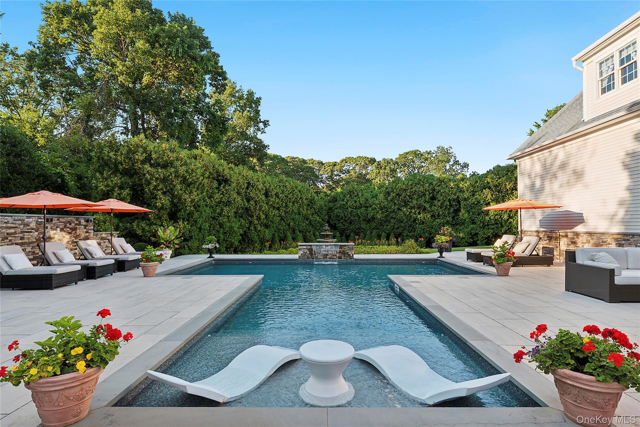 2 North Harbor Down Miller Place, NY 11764 - Photo 41 of 49 a view of a patio with couches table and chairs under an umbrella with potted plants
