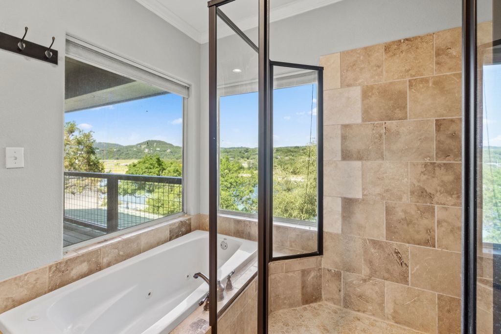 10800 Beach Road Leander, TX 78641 - Photo 19 of 39 Indulge in a relaxing soak with sweeping natural vistas from this elegant primary bathroom.