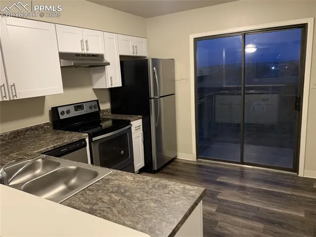 a kitchen with stainless steel appliances granite countertop a refrigerator and a stove top oven