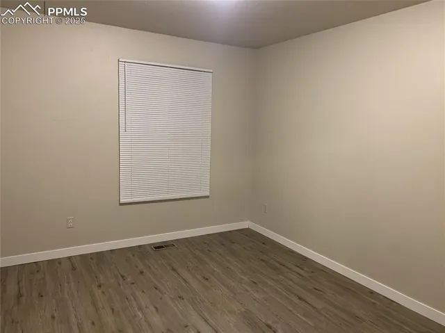 a view of a small space with wooden floor and a window