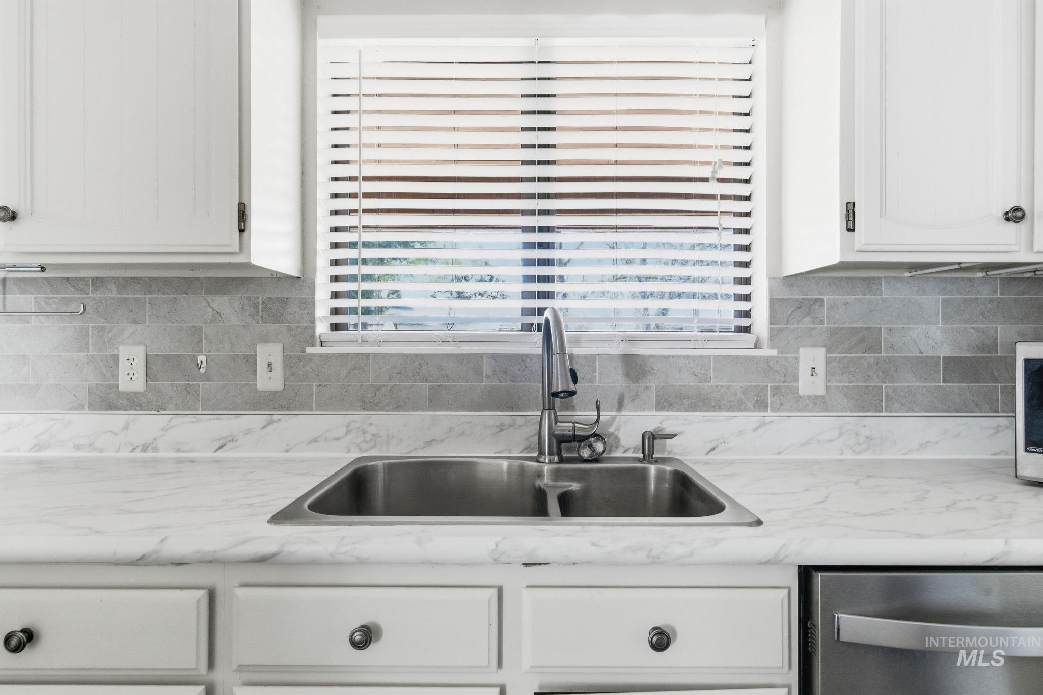 3911 South Constitution Way Boise, ID 83706 - Photo 15 of 40 Kitchen with light countertops, white cabinetry, and dishwasher