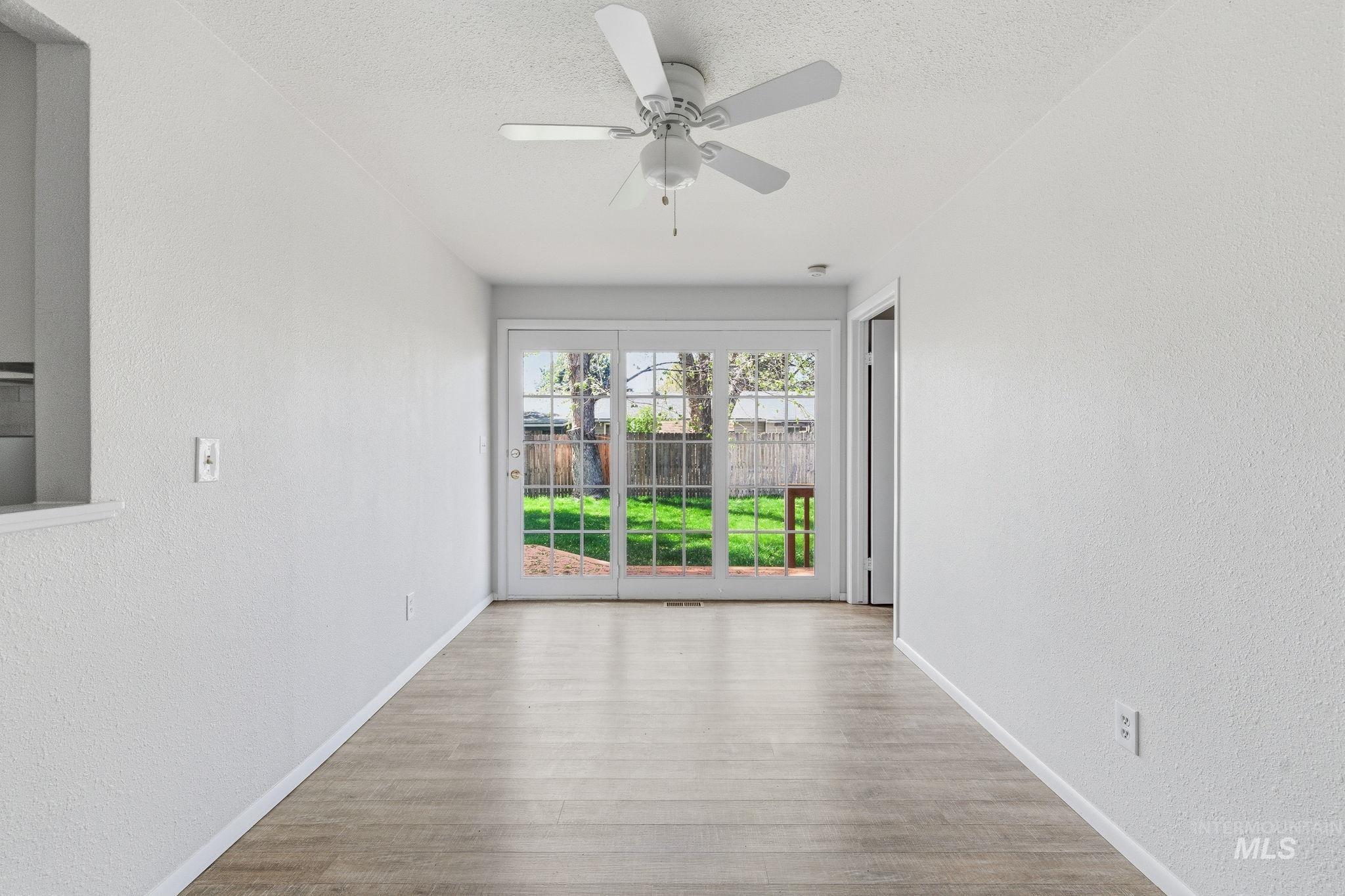 3911 South Constitution Way Boise, ID 83706 - Photo 17 of 40 Unfurnished room with a textured wall, a ceiling fan, wood finished floors, and a textured ceiling
