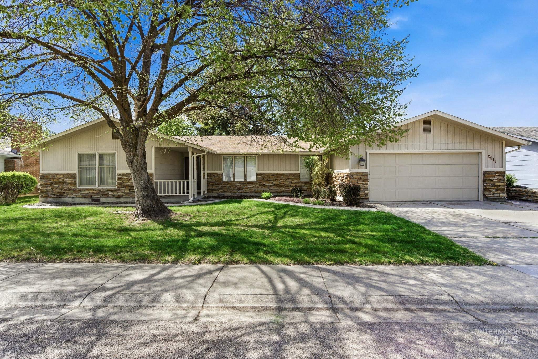 3911 South Constitution Way Boise, ID 83706 - Photo 2 of 40 Ranch-style home with stone siding, a garage, concrete driveway, and a front yard