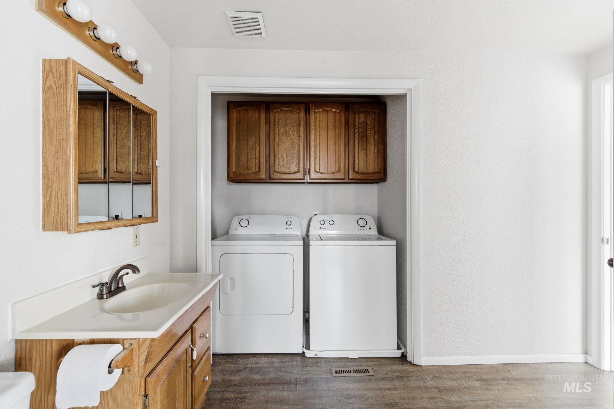 3911 South Constitution Way Boise, ID 83706 - Photo 21 of 40 Laundry area featuring cabinet space, separate washer and dryer, and dark wood-style floors