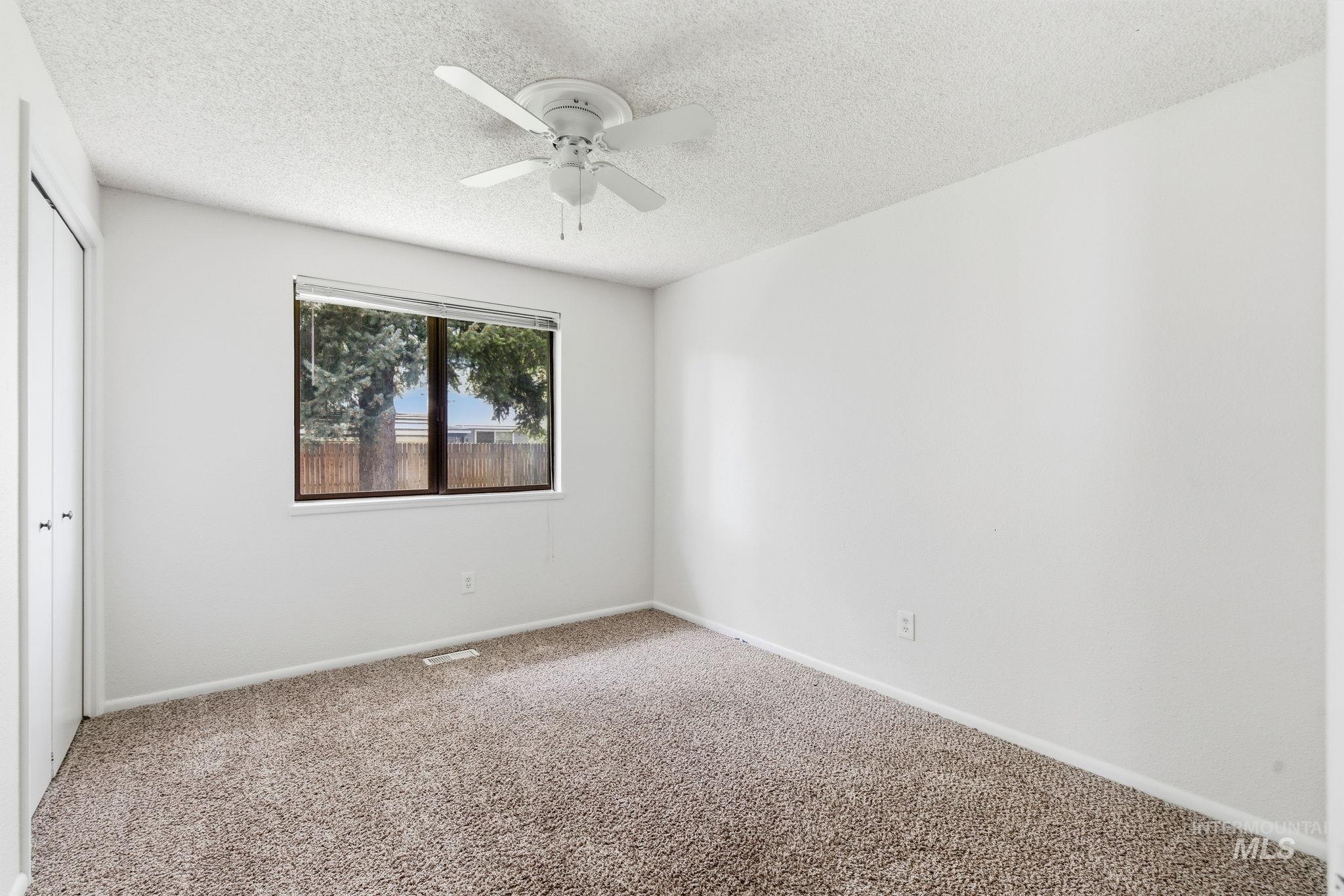 3911 South Constitution Way Boise, ID 83706 - Photo 24 of 40 Unfurnished bedroom featuring carpet flooring, a closet, a textured ceiling, and a ceiling fan